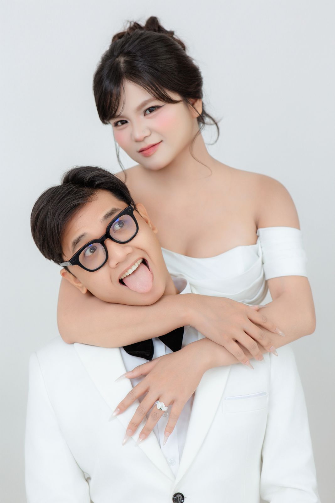 Cô dâu ôm chú rể đang lè lưỡi trêu